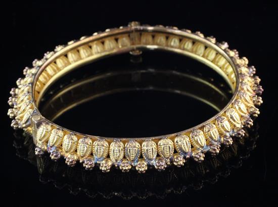 A Middle Eastern Etruscan style 22ct gold hinged bangle,